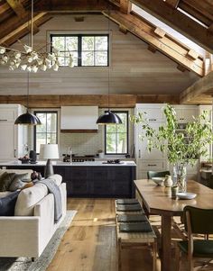 a living room filled with furniture next to a kitchen and dining room table in front of an open floor plan