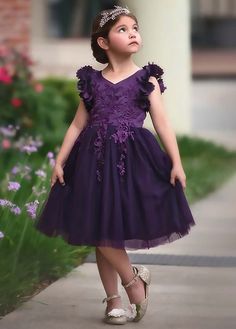 Fit for a princess, this dress has it all. Soft eggplant purple satin graced with a touch of lace, this dress is a showstopper! Sleeves are embellished with whimsical die cut flowers that will have all eyes on her. Tuling overlay skirt adds just the right touch of fullness and twirl. Fully lined with soft cotton, back zip. 100% poly self, 100% cotton lining. Machine wash, hang dry.