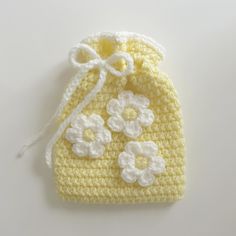 a crocheted yellow bag with white flowers on it