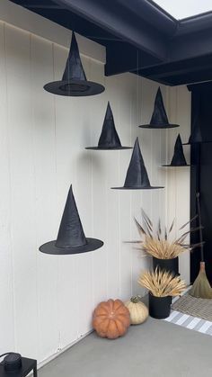 an outdoor area with black hats hanging from the ceiling and pumpkins on the ground