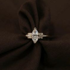 Engagement Ring: ✦ Main Stone Details ✧ Shape: Marquise Cut Moissanite ✧ Weight: 0.90 CT Approx ✧ Diamond Size: 10x5mm ✧ Color: White ✧ Clarity: VVS2 ✦ Side Stone Details ✧ Shape: Baguette Cut Moissanite ✧ Weight: 0.20 CT Approx ✧ Color: White ✧ Clarity: VVS2 ✦ While we do our best to showcase the true color of the stone, Moissanite are unique and vary in appearance. Colors may vary slightly due to your lighting and monitor display settings. ✦ Also Available in Aquamarine, Morganite, Blue Topaz, White Marquise Cut Rings With Baguette Diamonds, Platinum Cluster Ring With Baguette Diamonds For Wedding, Platinum Jewelry With Marquise Cut Baguette Diamonds, Silver Marquise Cut Diamond Ring With Baguette Diamonds, Marquise Diamond Cut Cluster Ring In White Gold, Silver Marquise Cut Diamond Ring With Baguettes, 14k White Gold Marquise Rings, Marquise Cluster Ring In White Gold With Diamond Cut, Silver Marquise Diamond Ring With Baguette Diamonds