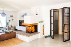 a living room filled with furniture and a fire place in the middle of the room