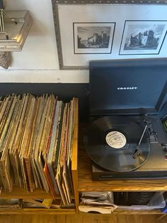 an old record player sitting on top of a wooden shelf filled with records and cds