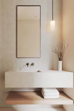 a white sink sitting under a mirror in a bathroom next to a shelf with towels