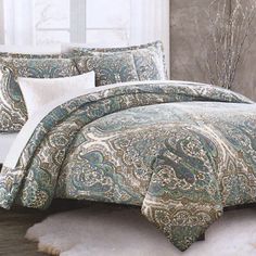 the comforter is made up with paisley print and white pillows on top of it