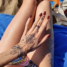 a woman laying on top of a blue beach towel