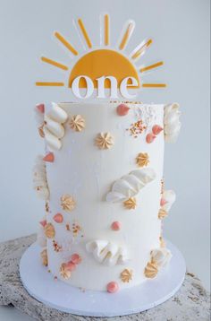 a white cake with orange and yellow decorations on it's top is sitting on a table