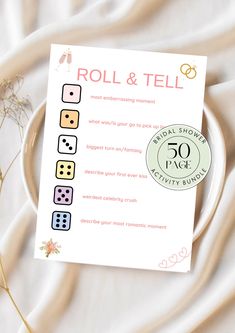 a roll and tell game sitting on top of a white cloth next to a flower