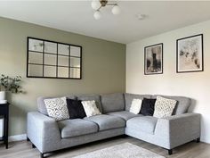 a living room with gray couches and pictures on the wall