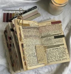 an open book sitting on top of a table next to a candle