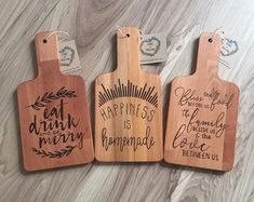 three wooden cutting boards with different sayings on them