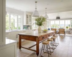 a kitchen island with stools in front of it and a potted plant on top