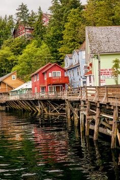 colorful houses line the water in front of a dock with boats parked on it's sides