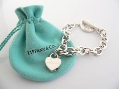 Offered for sale is a wonderful and rare Tiffany and Co. Sterling Silver "Mom" Heart Padlock bracelet.  The piece is made from substantial and bright Tiffany silver, and yet retains a very feminine feel to it.  Attached to its very substantial Tiffany & Co Silver Toggle charm bracelet is a Heart padlock charm with "Mom" written in beautiful script.  The"Mom" padlock charm opens and closes and thus can be used as a charm on a necklace or as part of another charm bracelet! Super versatile Tiffany And Co Jewelry Valentines Day, Elegant Valentine's Day Bracelets With Toggle Clasp, Elegant Heart Bracelet With Toggle Clasp For Valentine's Day, Luxury Sterling Silver Heart Bracelet For Gift, Elegant Heart Bracelet With Toggle Clasp For Gift, White Gold Jewelry With Clasp For Gift, Luxury Heart Bracelet As Gift, Valentine's Day Gift Bracelet With Toggle Clasp, Luxury Heart Charm Bracelet Gift