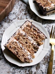 two slices of cake sitting on top of white plates next to a knife and fork