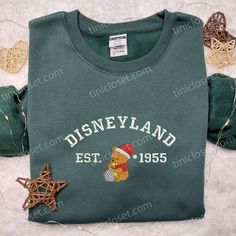 Disneyland Pooh Santa Hat Embroidered Sweatshirt, Disney Christmas Embroidered Sweatshirt, Best Christmas Gift Ideas Step into the enchanting world of Tinicloset, where we create fashion that’s as sweet as honey and as adorable as Winnie the Pooh himself. Our Disneyland Pooh Santa Hat embroidered sweatshirt collection is a whimsical celebration of the festive season, seamlessly blending Disney magic with holiday cheer. Each piece is a work of art, designed to make you feel like you’v Disney Crew Neck Sweatshirt With Embroidered Logo, Disney Cotton Sweatshirt For Winter, Winter Disney Cotton Sweatshirt, Disney Sweatshirt For Winter Fan Events, Sweatshirt Collection, Embroidered Sweatshirt, Christmas Gift Ideas, Disney Christmas, Best Christmas