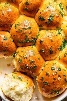 a white plate topped with rolls covered in cheese and parmesan sprinkles