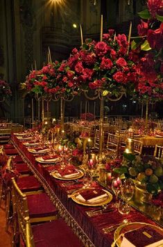 a long table is set with red and gold place settings