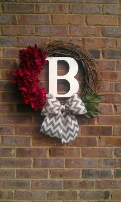 a brick wall with a wreath, bow and letter b hanging on it's side