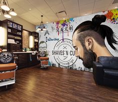 the interior of a barbershop with an image of a man's head on the wall