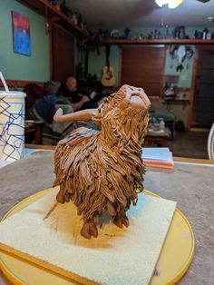 a wooden sculpture of a goat on a table