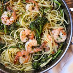 pasta with shrimp, broccoli and spinach in a pan on a table