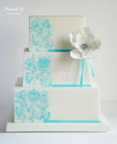 a three tiered cake decorated with blue and white flowers