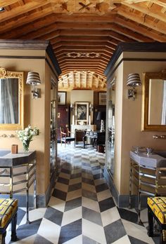 a hallway with checkered flooring and wooden ceiling