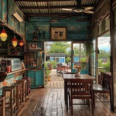 the inside of an old fashioned restaurant with wooden floors and tables, chairs, and lots of potted plants