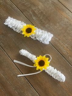 two white garters with yellow sunflowers on them sitting on a wooden floor