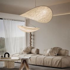 a living room with two couches and a lamp hanging from the ceiling above it