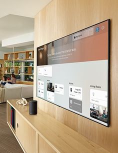 a living room filled with furniture and a large flat screen tv mounted to the wall