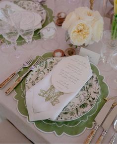 the table is set with white and green place settings