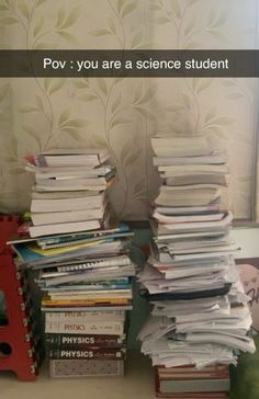 a stack of books sitting on top of a table next to a red box filled with papers