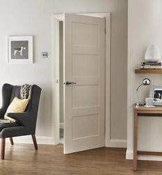 a living room with a chair, table and open door