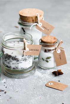 three glass jars filled with different types of herbs and spices, one has a tag that says lavender