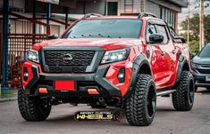 a red pick up truck parked in front of a building