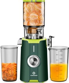 a green juicer filled with oranges next to two glass containers full of liquid