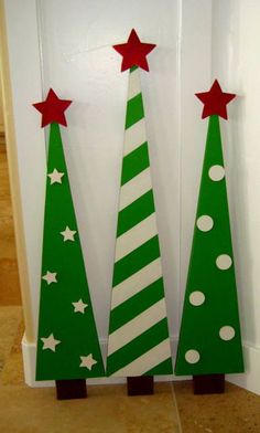 two wooden christmas trees decorated with red and white stars on the top one is green