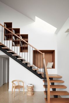 an image of a living room with stairs and bookshelves on the wall above it