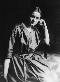 black and white photograph of a woman sitting in a chair with her hand on her head