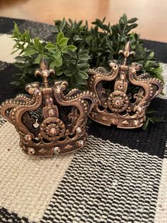 two metal crowns sitting on top of a table