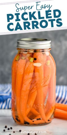 a jar filled with pickled carrots sitting on top of a table next to an orange carrot