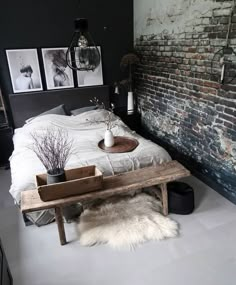 an instagram photo of a bedroom with exposed brick wall and bed frame in the middle