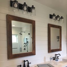 a bathroom with two sinks and mirrors on the wall