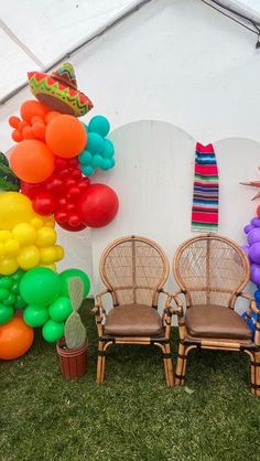 there are many balloons and chairs in front of a tent with a mexican theme on it