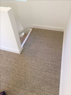 an empty room with carpet and white walls