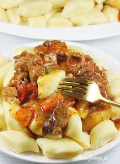 two plates filled with pasta and meat covered in sauce