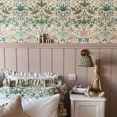 a bedroom with pink walls and floral wallpaper