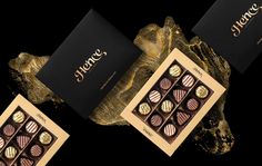 three boxes of chocolates with gold foil on the top and one box filled with different types